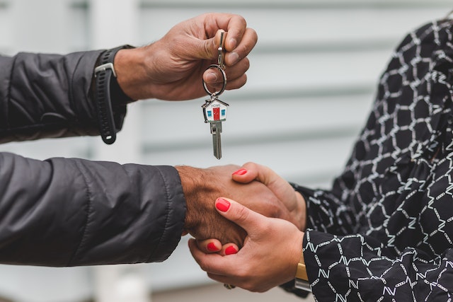 Man handing key to a woman for a home